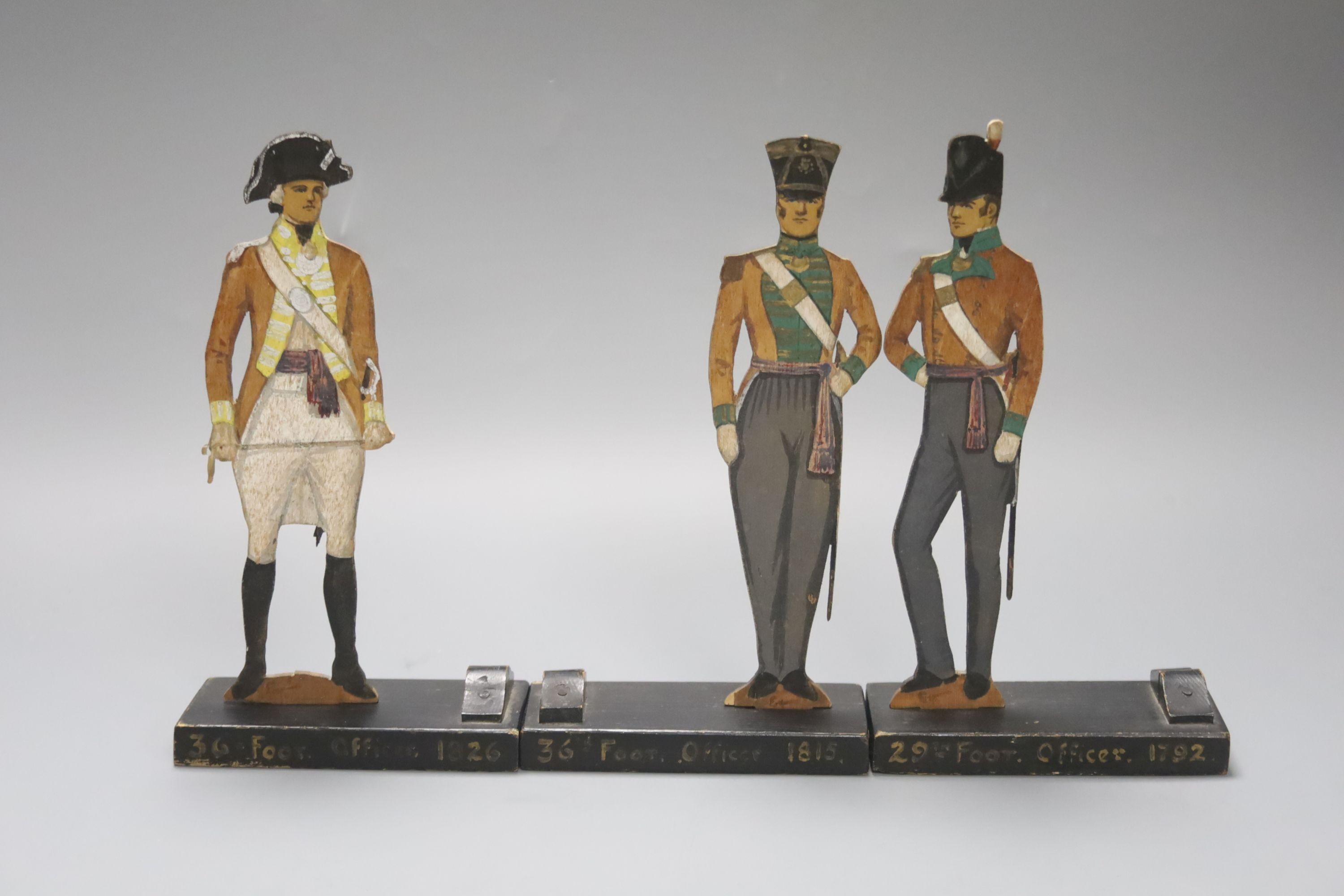 Three painted wood ‘foot officer’ menu holders 19cm